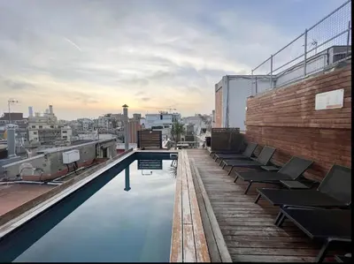 a rooftop swimming pool with chairs on a building at Enjoybcn Gaudi Apartments in Barcelona