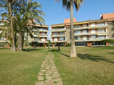 a walkway in the grass in front of a building at GAVA4 BEACHFRONT Apartment BARCELONA in Gavà