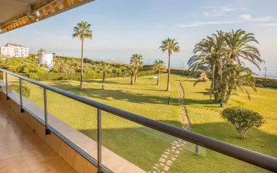a balcony with a view of a park with palm trees at GAVA4 BEACHFRONT Apartment BARCELONA in Gavà