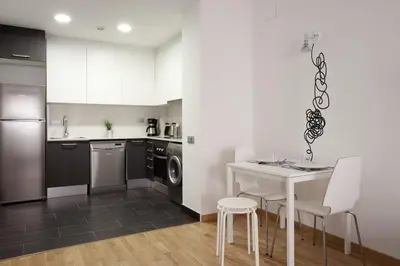 a kitchen with a white table and chairs and a sink at AB Gracia Sant Salvador in Barcelona