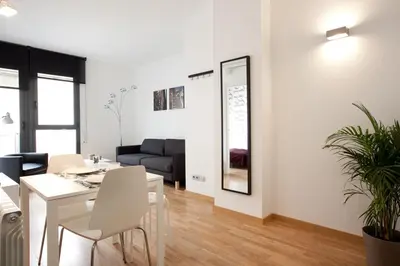 a dining room and living room with a white table and chairs at AB Gracia Sant Salvador in Barcelona