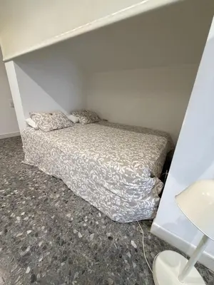a small bedroom with a bed in the corner at Apartamento con piscina cerca de Barcelona in Masnou