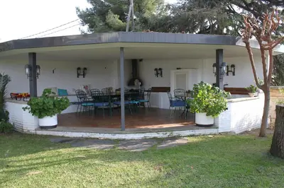 a house with a deck with a table and chairs at Apartamento con piscina cerca de Barcelona in Masnou