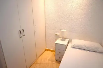 a small bedroom with a bed and a cabinet at Homenfun Barcelona Sagrada Familia Glories in Barcelona