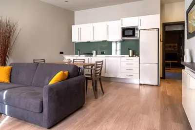 a living room and kitchen with a couch and a table at Inspired by EnjoyApartments in Barcelona