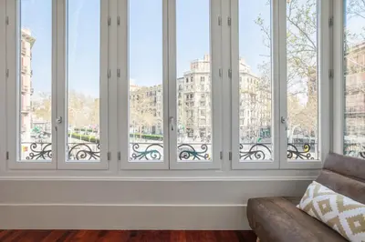 a row of windows in a room with a couch at Art House Granvia in Barcelona