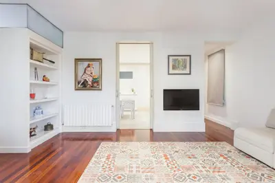 a living room with white walls and a flat screen tv at Art House Granvia in Barcelona