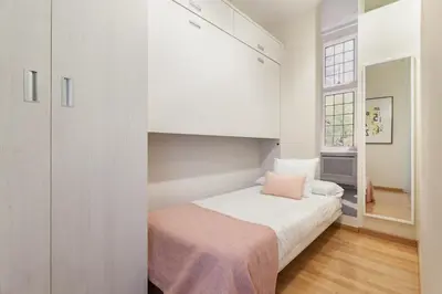 a bedroom with a bed with white walls and a window at Art House Sagrada Familia in Barcelona