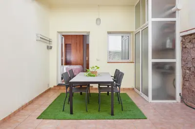 a dining room with a table and chairs on a green rug at Art House Sagrada Familia in Barcelona
