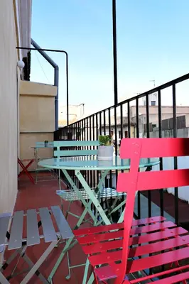 a table and a red bench on a balcony at ClassBedroom Port Ramblas in Barcelona
