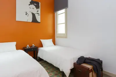 two beds in a room with orange walls at Casa Cosi - Mallorca 2 in Barcelona