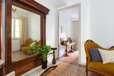 a living room with a mirror and a yellow chair at Casa Cosi - Mallorca 2 in Barcelona
