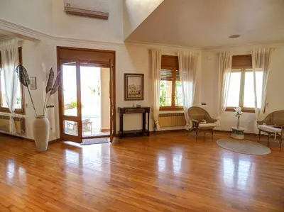 a large living room with wooden floors and windows at Villa El Faro by Hello Homes Sitges in Vilanova i la Geltrú