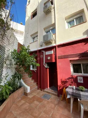a red door of a building with a table in front at Cozy Suite apartment, WiFi! in Santa Coloma