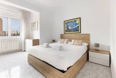 a bedroom with a large bed with white sheets at Besos · Bright apartment close to congress & port in Sant Adria de Besos