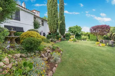 a garden in front of a white house at Comarquinal Bioresort Penedes in San Quintín de Mediona