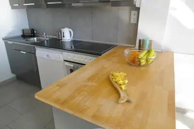 a kitchen with a wooden counter top with a bowl of fruit at Cala Balmins Sea View in Sitges