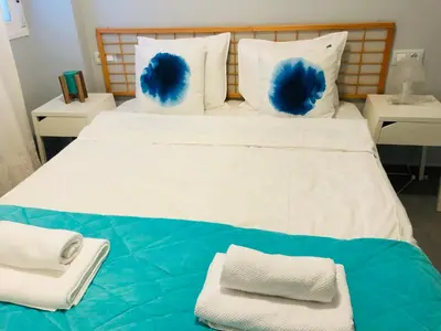 a large bed with blue feathers on top of it at Cala Balmins Sea View in Sitges