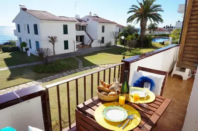 a table on a balcony with a view of the ocean at Cala Balmins Sea View in Sitges