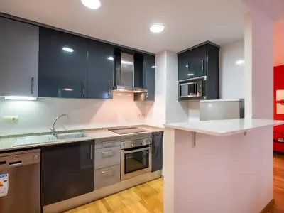 a kitchen with stainless steel appliances and black cabinets at Stay Barcelona Maragall in Barcelona