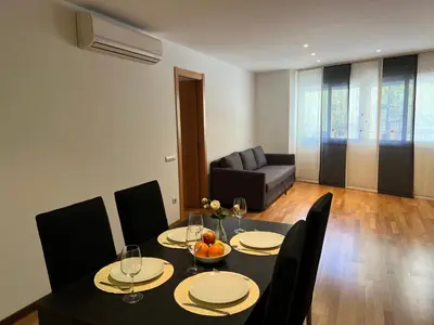 a dining room with a table and chairs and a couch at Stay Barcelona Maragall in Barcelona