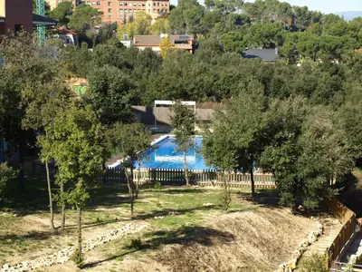 a swimming pool in a yard with trees at Aparthotel del Golf in Sant Cugat del Vallès