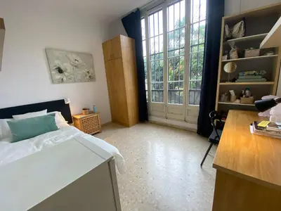 a bedroom with a bed and a desk and a window at Barcelona Housing recommend for Students in Barcelona