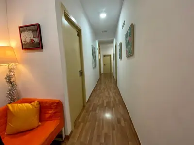 a hallway with an orange couch and a hallway with paintings at Barcelona Housing recommend for Students in Barcelona
