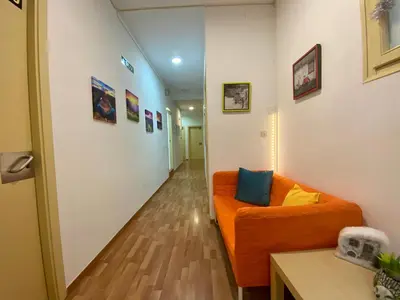 a hallway with an orange couch in a room at Barcelona Housing recommend for Students in Barcelona