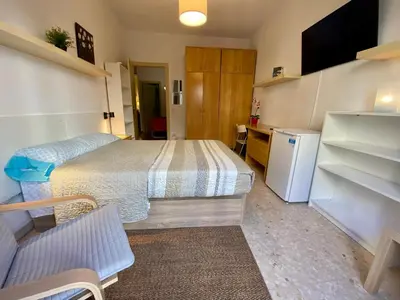 a small bedroom with a bed and a refrigerator at Barcelona Housing recommend for Students in Barcelona