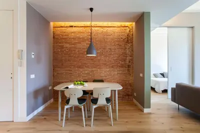 a dining room with a brick wall and a table and chairs at DestinationBCN Universitat Apartments in Barcelona