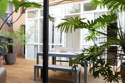 an indoor garden with a table and plants at DestinationBCN Universitat Apartments in Barcelona
