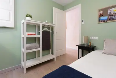 a bedroom with a white book shelf next to a bed at Casa Cosi - Mallorca 3 in Barcelona
