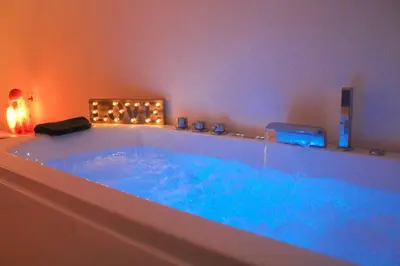 a large tub with blue water in a bathroom at Barceló Apartaments in Monistrol