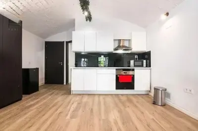 a large kitchen with white cabinets and a hard wood floor at Barceló Apartaments in Monistrol