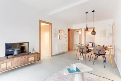 a living room with a television and a table with chairs at Sweett - Callao Plaza in Barcelona