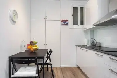 a kitchen with a table and two chairs in it at Camp Nou , Fira Barcelona Apartment in Hospitalet de Llobregat