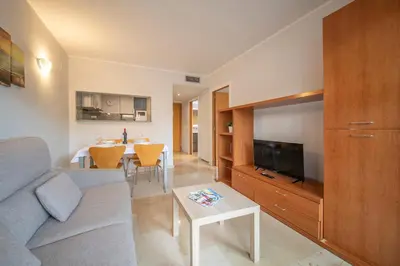 a living room with a couch and a tv and a table at Aparthotel Marsol in Castelldefels