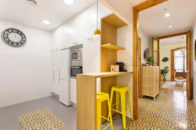 a kitchen with a counter and yellow stools at Central Apartments Barcelona in Barcelona