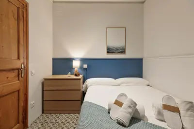 a bedroom with a bed with a blue headboard at Central Apartments Barcelona in Barcelona
