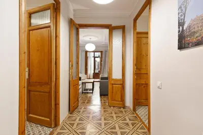 a hallway with wooden doors and a tile floor at Central Apartments Barcelona in Barcelona
