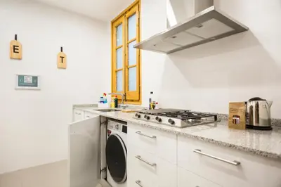 a white kitchen with a stove and a sink at Central Apartments Barcelona in Barcelona