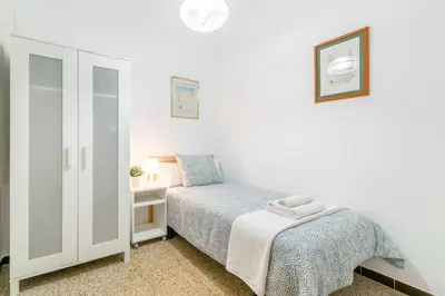 a small bedroom with a bed and a cabinet at Confort Barcelona Rentals in Barcelona