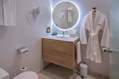 a white bathroom with a sink and a mirror at SERHS Carlit Boutique Hotel in Barcelona