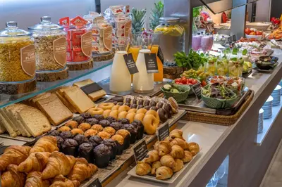 a buffet filled with different types of bread and pastries at SERHS Carlit Boutique Hotel in Barcelona