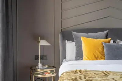 a bedroom with a bed with yellow pillows and a side table at TSA Gran Via in Barcelona