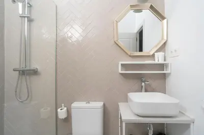 a bathroom with a shower and a toilet and a mirror at TSA Gran Via in Barcelona