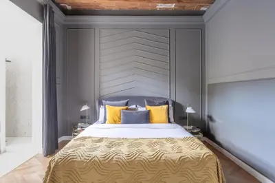 a bedroom with a large bed with yellow and blue pillows at TSA Gran Via in Barcelona