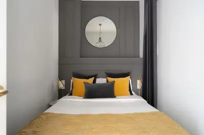 a bedroom with a bed with yellow and black pillows at TSA Gran Via in Barcelona