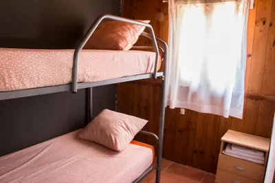 a bedroom with two bunk beds and a window at Pinedes Verd in La Torre de Claramunt
